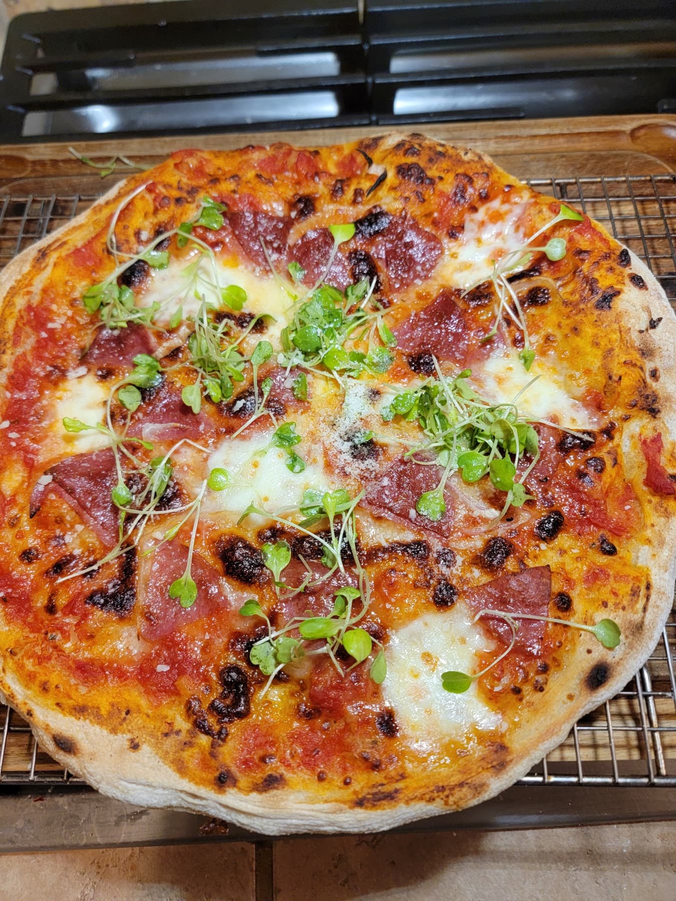 Lowkey Dough Club pizza with blistered crust and fresh greens