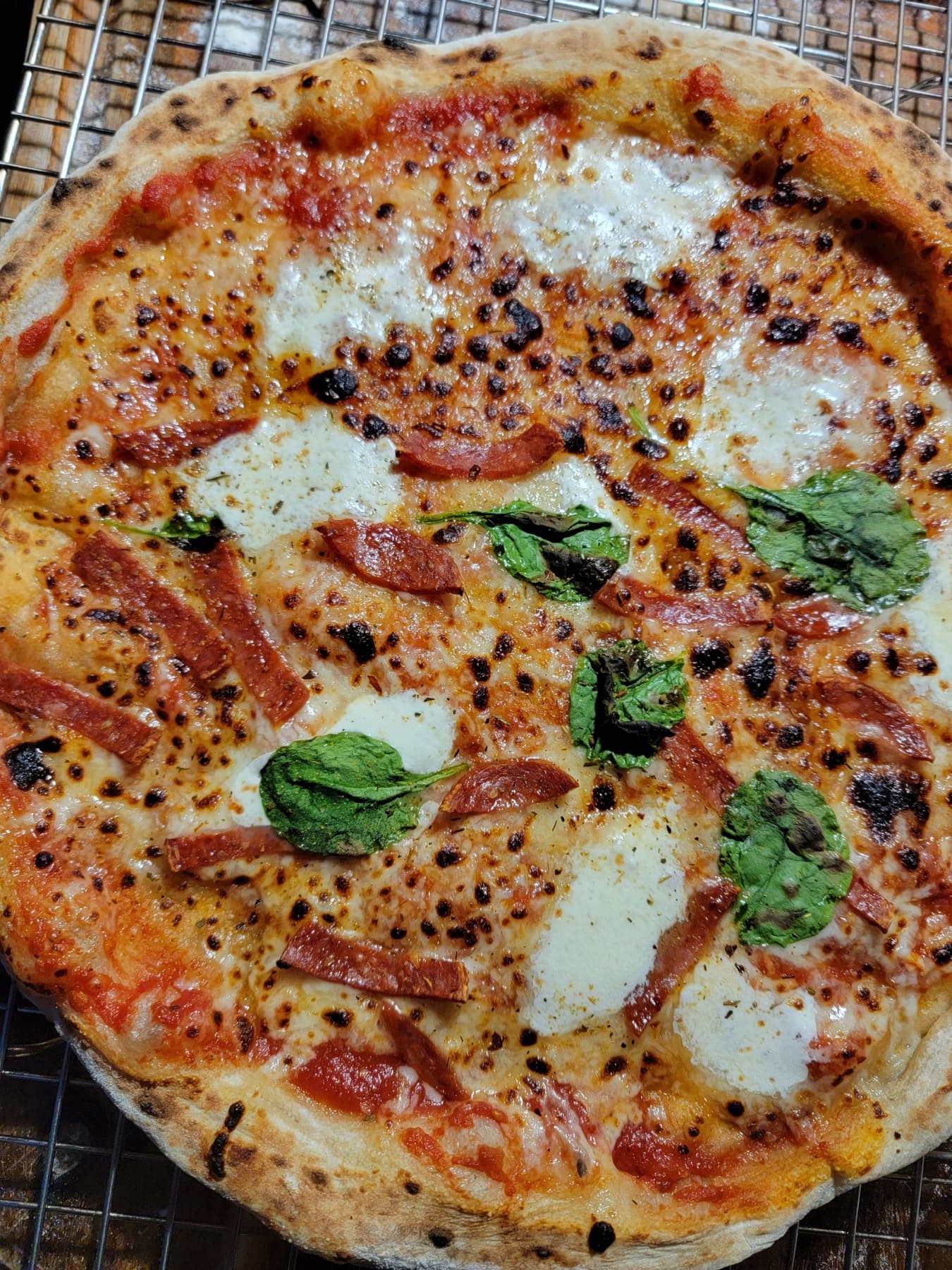 A Lowkey Dough Club pizza with a blistered edge and melted cheese
